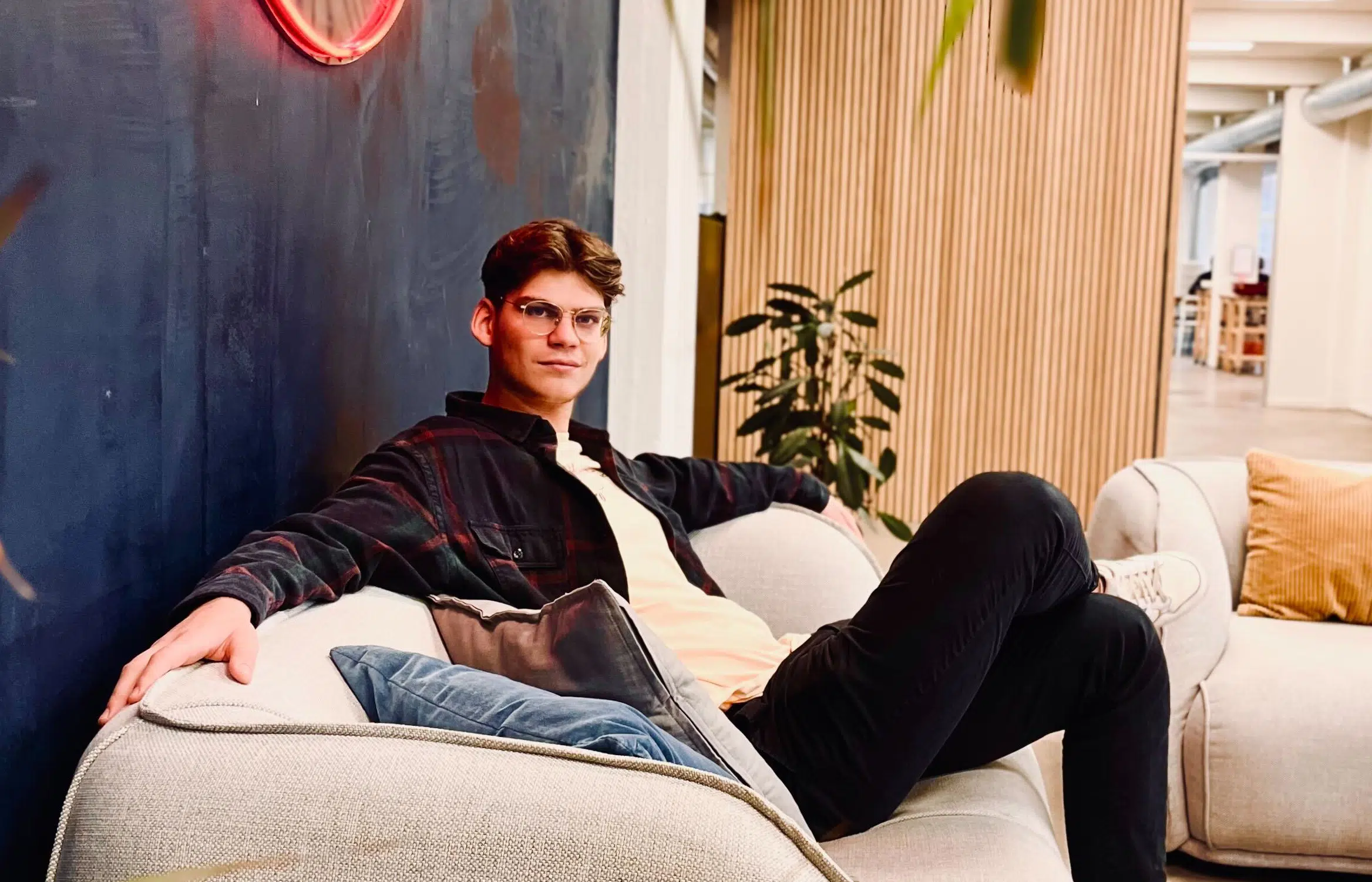 Kasper Nikolajsen Dahl, UX/UI designer at Twentyfour, is sitting in a couch.